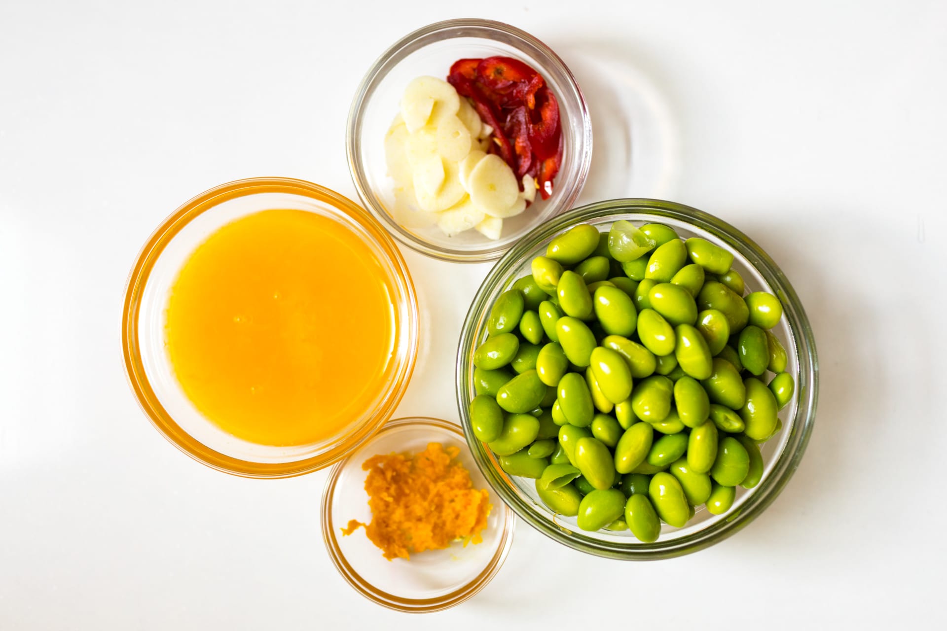 Four small, glass bowls containing some of the ingredients for a stir fry